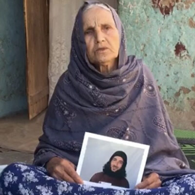 Twitter image of Asadullah Haroon Gul's mother holding up pictures of him while he is locked up in Guantanamo.